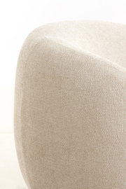 Close-up van een beige stoel met een gestructureerd stoffen oppervlak, gezien vanaf de zijkant