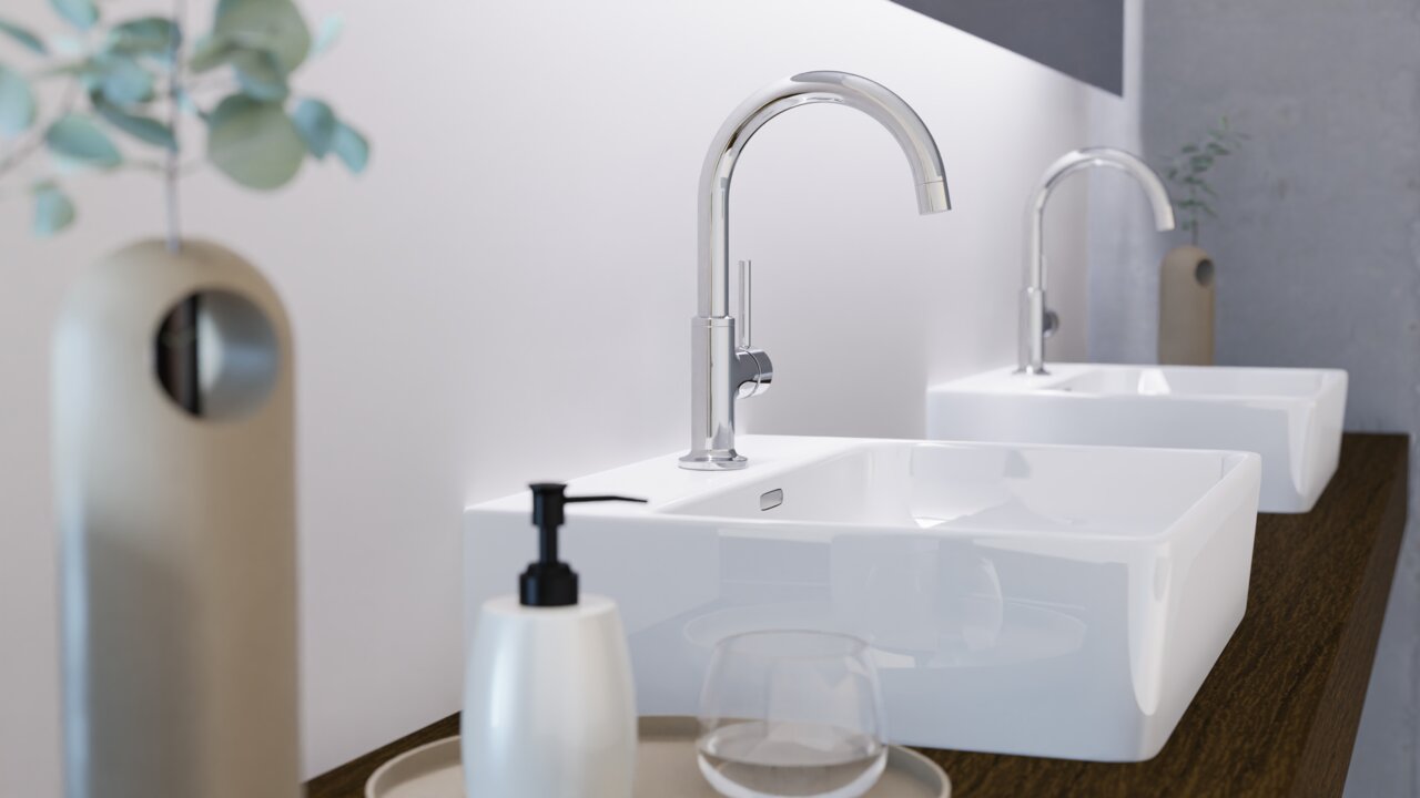 Moderne Waschtischarmatur in seitlicher Perspektive mit elegantem, gebogenem Auslauf und glänzender Chromoberfläche, installiert auf einem weißen Waschbecken.