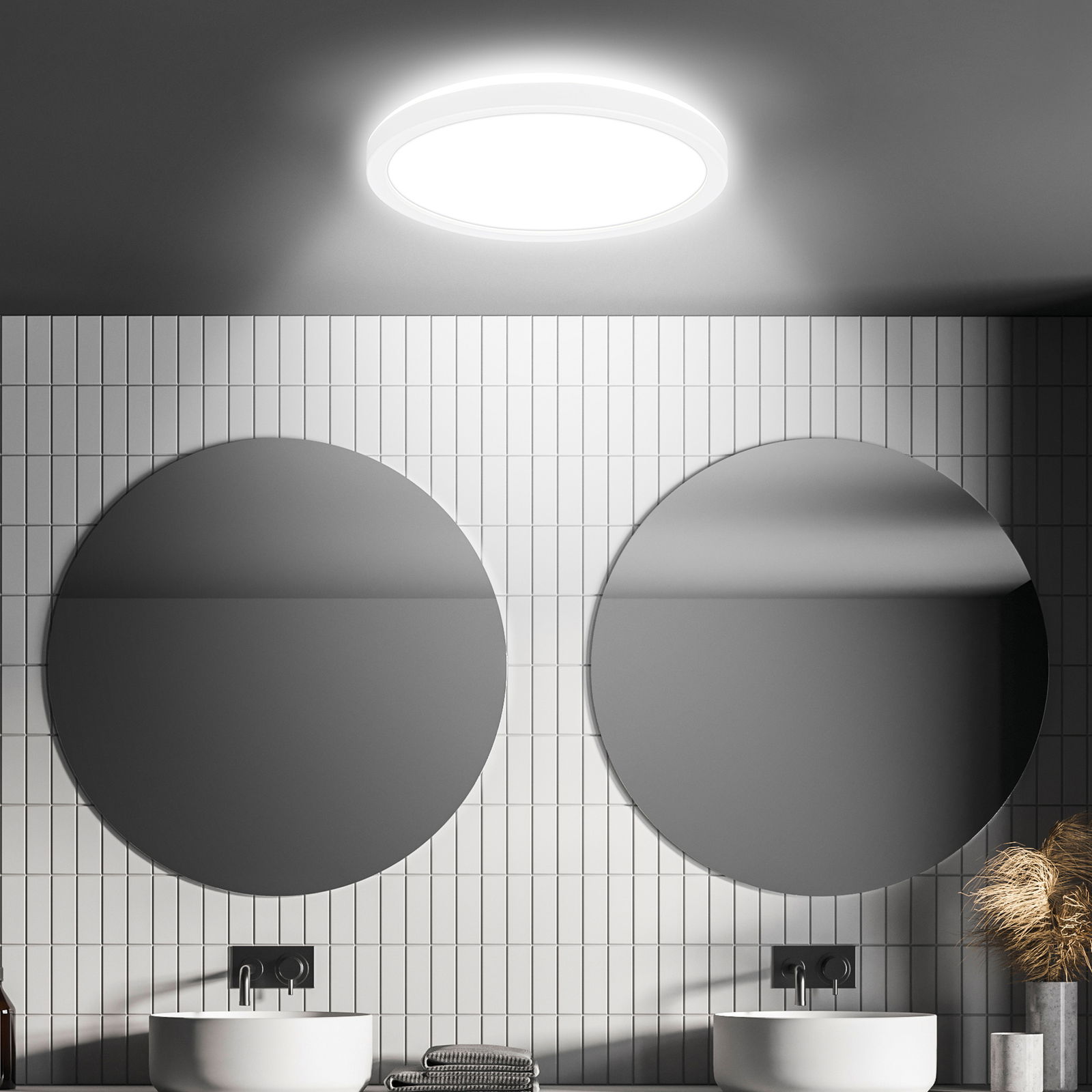 Moderne LED-Deckenleuchte mit Bewegungssensor, von unten betrachtet, in einem stilvollen Badezimmer mit zwei runden Spiegeln und weißen Fliesen.