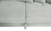 Nahaufnahme einer hellgrauen, gerippten Stoffoberfläche eines Sofas mit Kissen, von oben betrachtet.