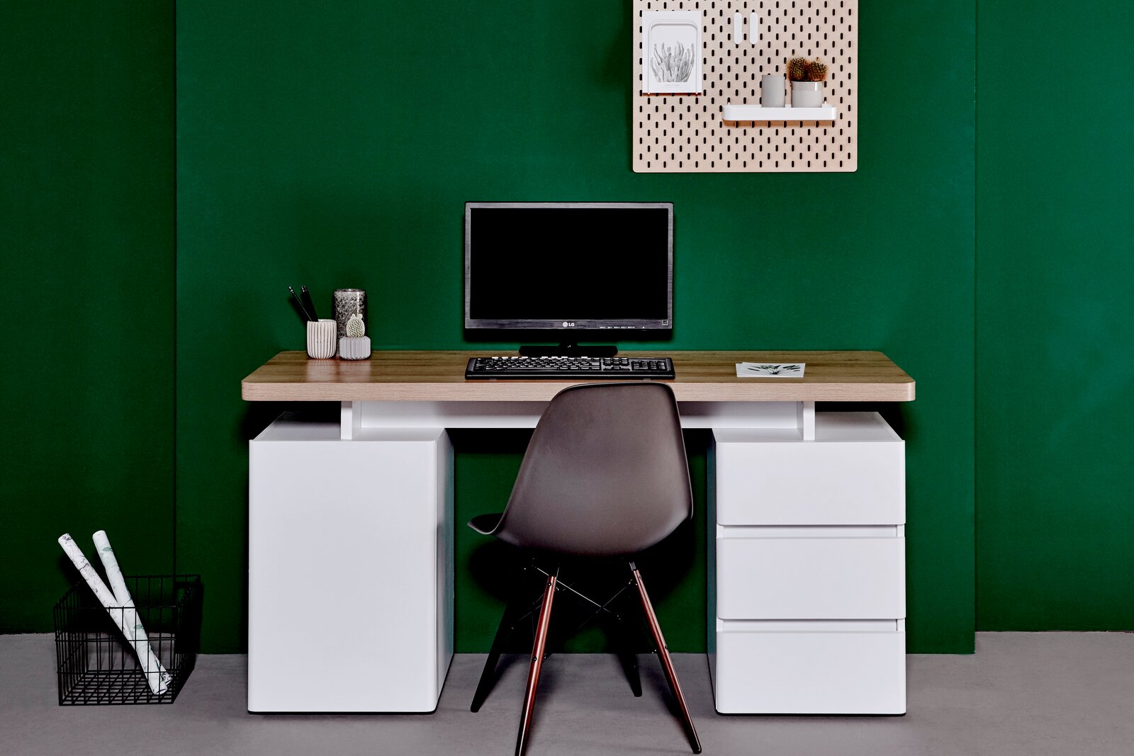 Moderner Schreibtisch mit Holzplatte und weißen Schubladen, frontal fotografiert, mit Computer und Dekorationen.