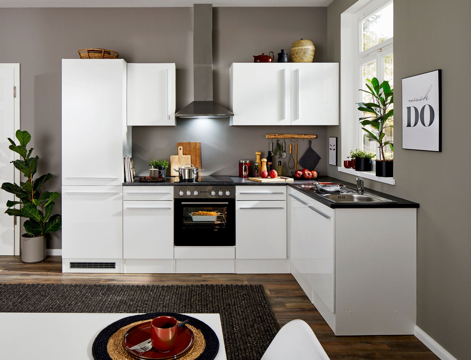 Moderne weiße Küche mit Eckunterschrank, Blick von vorne, ausgestattet mit Herd, Spüle und dekorativen Elementen.