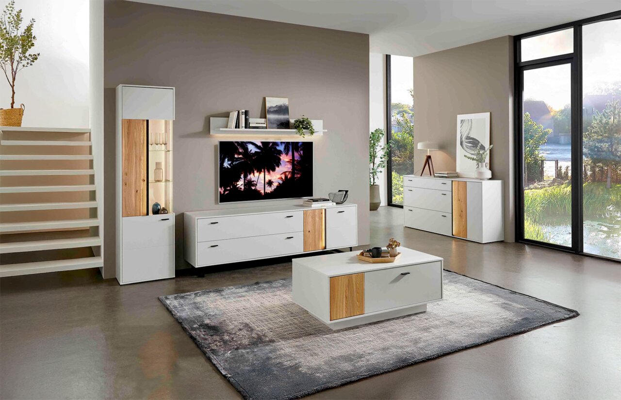 Modernes Wohnzimmer mit weißem Couchtisch und TV-Lowboard, beide mit Holzakzenten, aus der Perspektive von vorne.