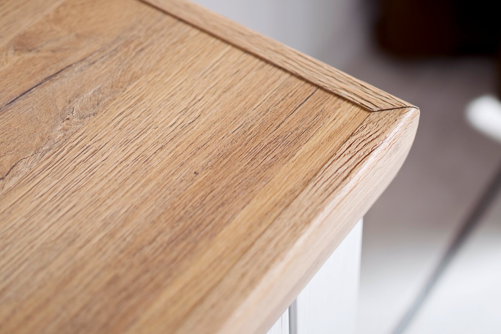 Detailfoto van een houten plaat met eikenlook en afgeronde randen, vanuit een schuin perspectief van bovenaf