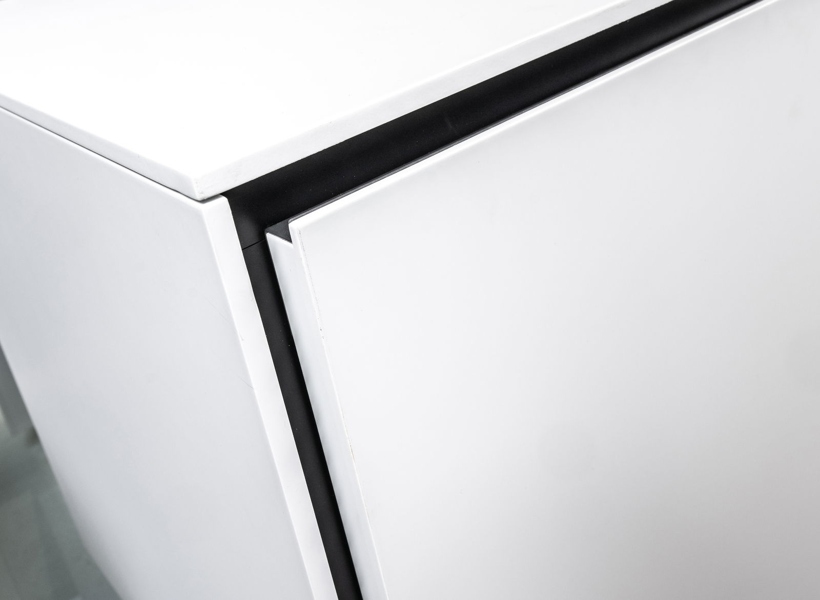 Nahaufnahme eines weißen TV-Elements mit moderner, minimalistischer Kante, Perspektive von oben.