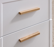 Nahaufnahme eines weißen Unterschranks mit zwei Schubladen und Holzgriffen, seitliche Perspektive