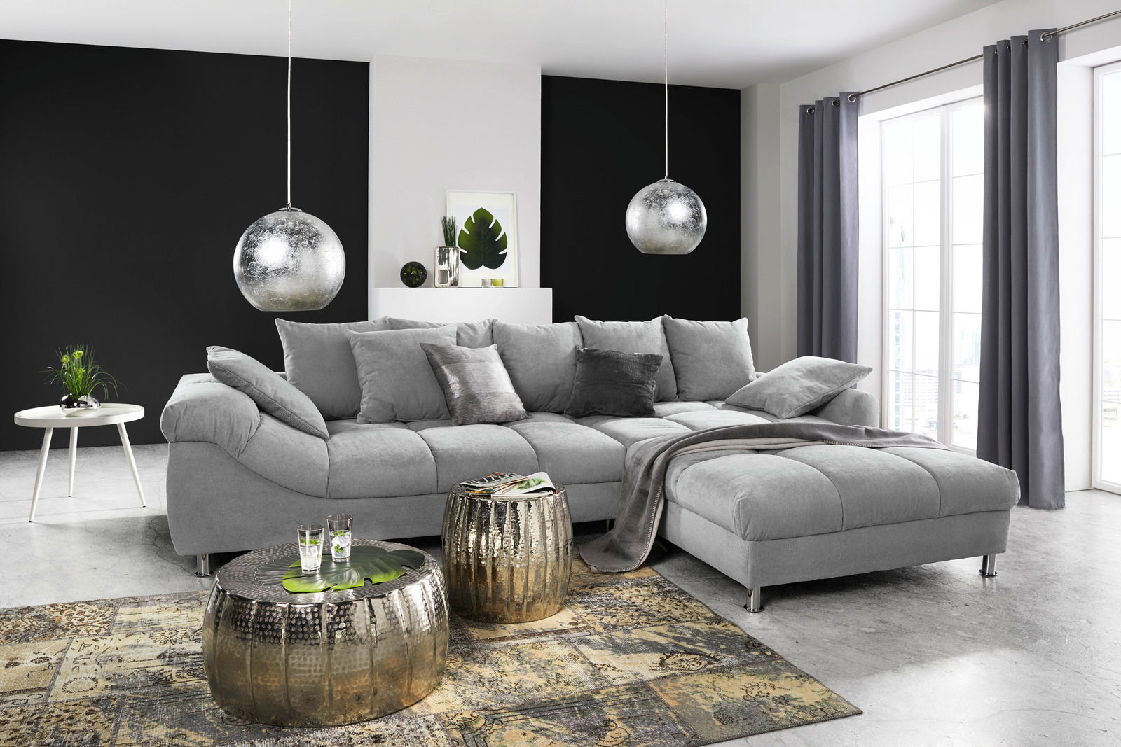 Graue Rundecke (L) in modernem Wohnzimmer, seitliche Perspektive, mit dekorativen Kissen und Decke, umgeben von stilvollen Möbeln und Accessoires.