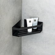 Schwarze Eckablage Meleto an einer grauen Wand montiert, mit zwei Tuben darauf, seitliche Perspektive.