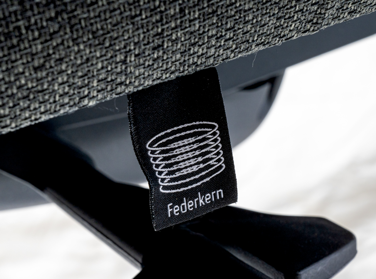 Nahaufnahme eines Drehstuhls mit Federkern-Label, seitliche Perspektive