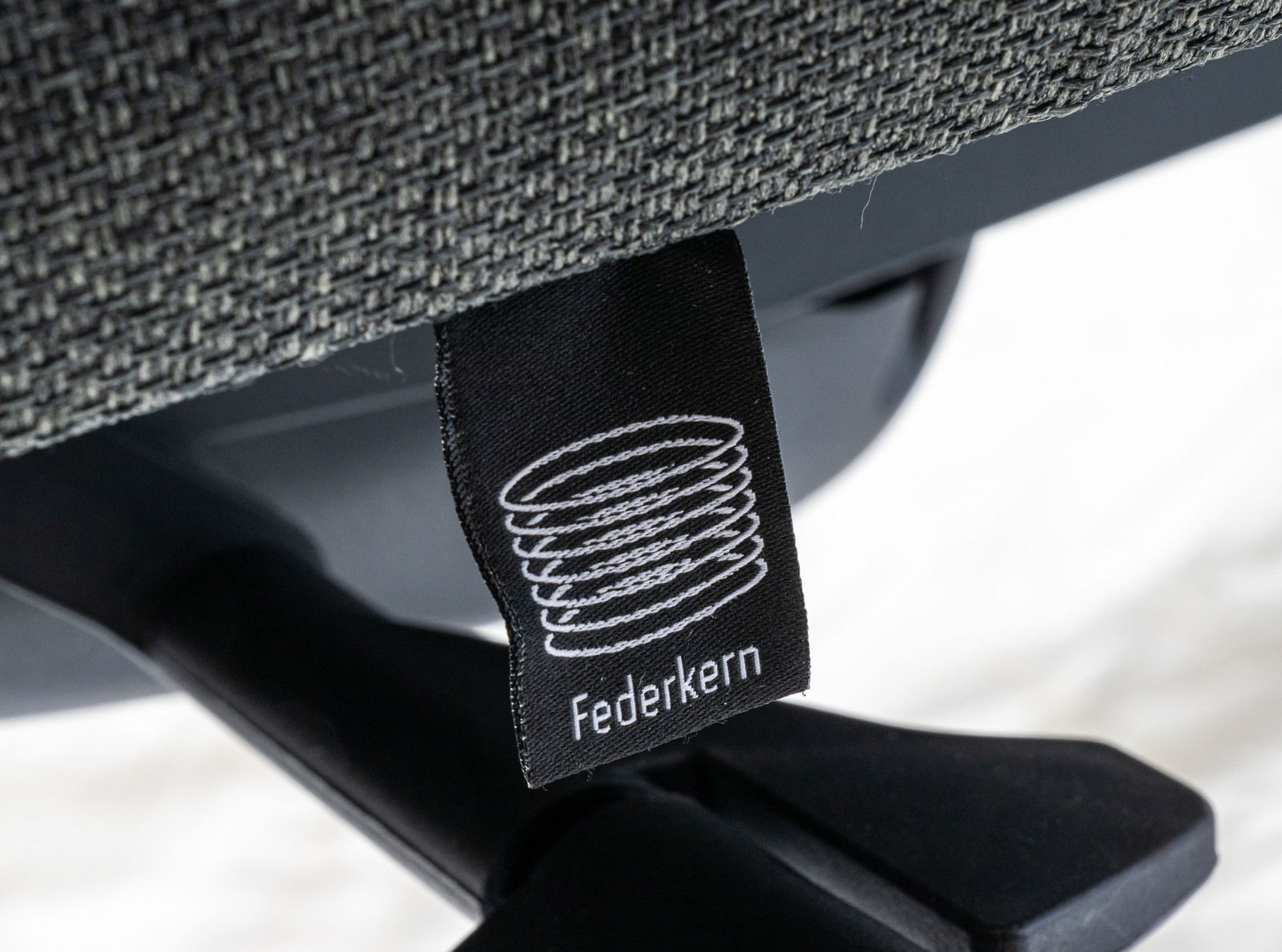 Nahaufnahme eines Drehstuhls mit Federkern-Label, seitliche Perspektive