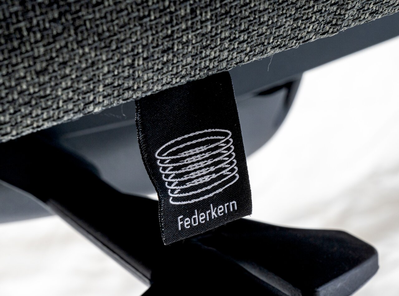 Nahaufnahme eines Drehstuhls mit Federkern-Label, seitliche Perspektive
