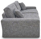 Seitenansicht eines großen, gepolsterten Big-Sofas mit strukturiertem Stoffbezug und mehreren Kissen.