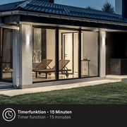 Moderne Akku-Außenwandleuchte an einem Haus bei Dämmerung, seitliche Perspektive