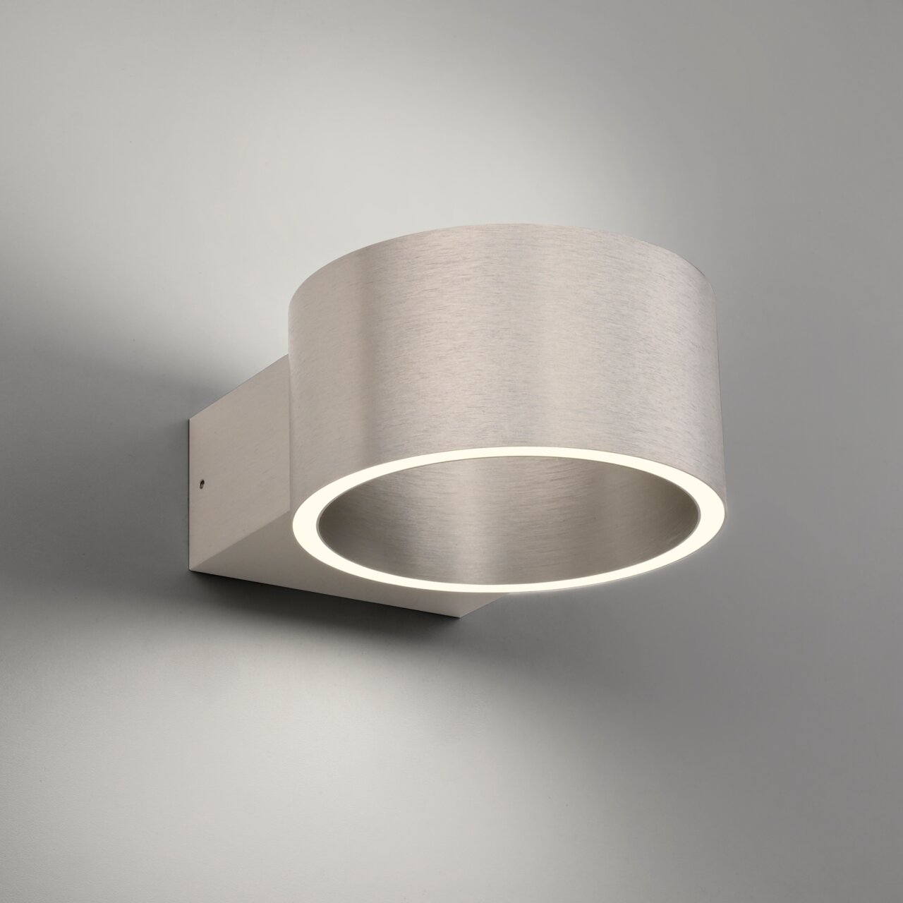 Moderne Wandleuchte PURE Clipse aus gebürstetem Metall, seitliche Perspektive, mit leuchtendem Ring.