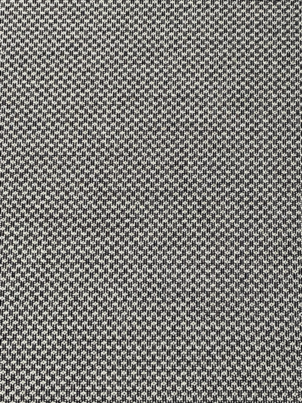 Nahaufnahme eines strukturierten Stoffmusters in Schwarz und Weiß, von oben betrachtet.