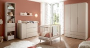 Helles Babyzimmer mit weißem Babybett, Wickelkommode, Regal und großem Kleiderschrank vor terrakottafarbener Wand, aufgenommen in frontaler Perspektive mit leichtem Weitwinkel