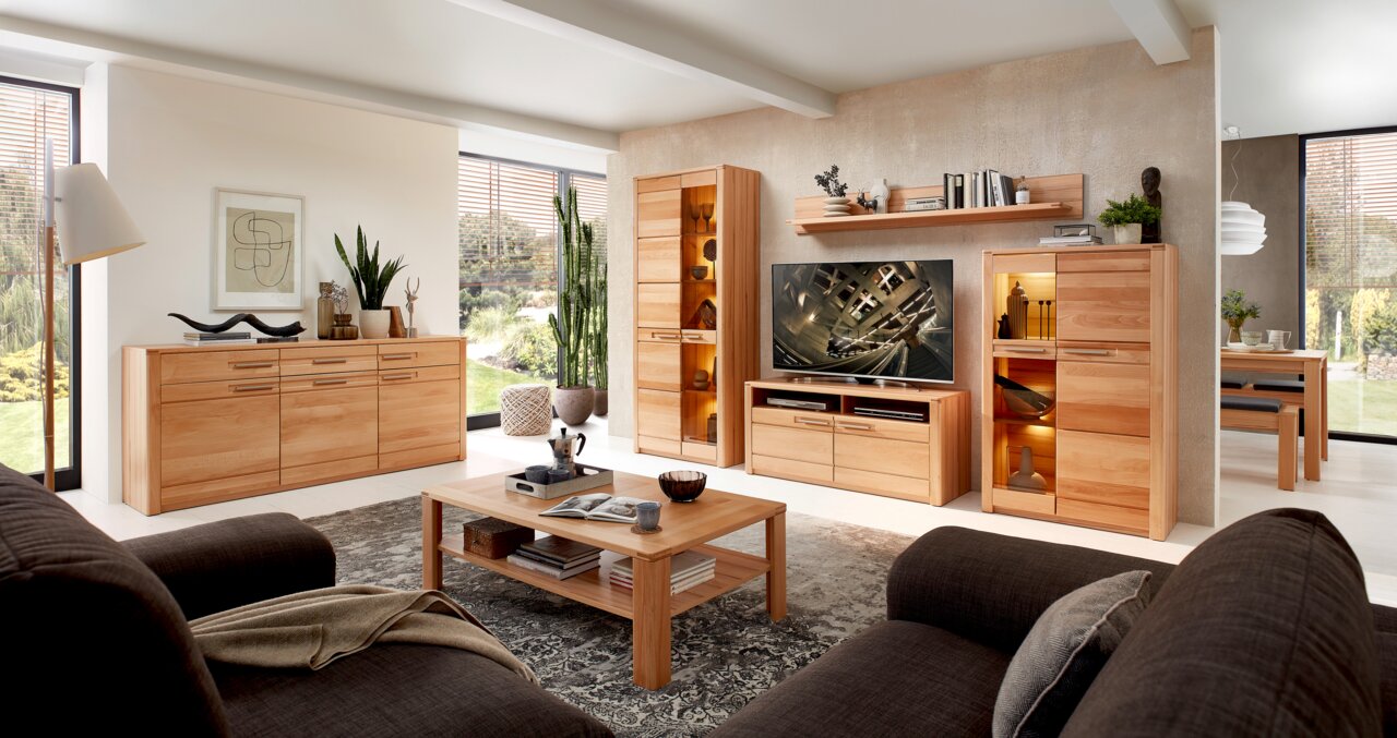 Z2 TV-Lowboard NATURE ONE Wohnzimmer mit modernen Holzmöbeln, darunter ein TV-Lowboard, Vitrinen und ein Couchtisch, aus der Perspektive einer gemütlichen Sitzecke betrachtet.