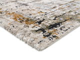 Nahaufnahme eines Designer-Teppichs mit abstraktem Muster in Beige-, Grau-, Grün- und Orangetönen, perspektivisch von der Seite aufgenommen.