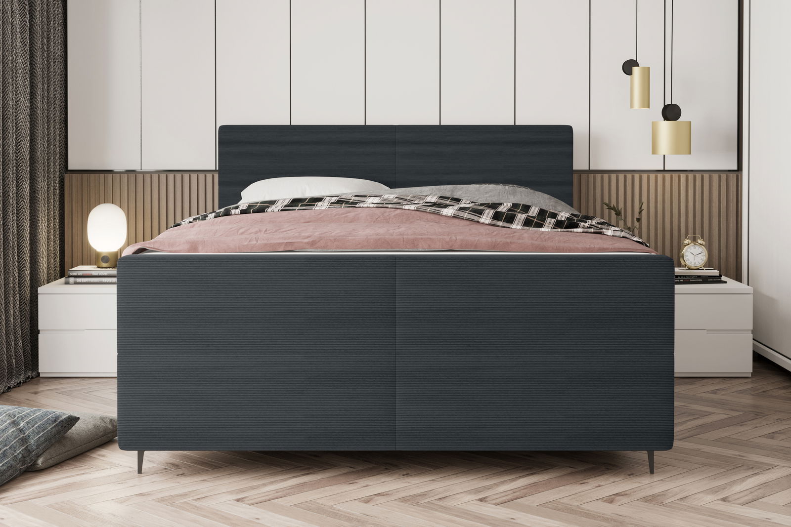 Frontale Ansicht eines modernen Boxspringbetts mit dunklem Stoffbezug, dekoriert mit einer rosa und karierten Decke, flankiert von Nachttischen und stilvollen Lampen.
