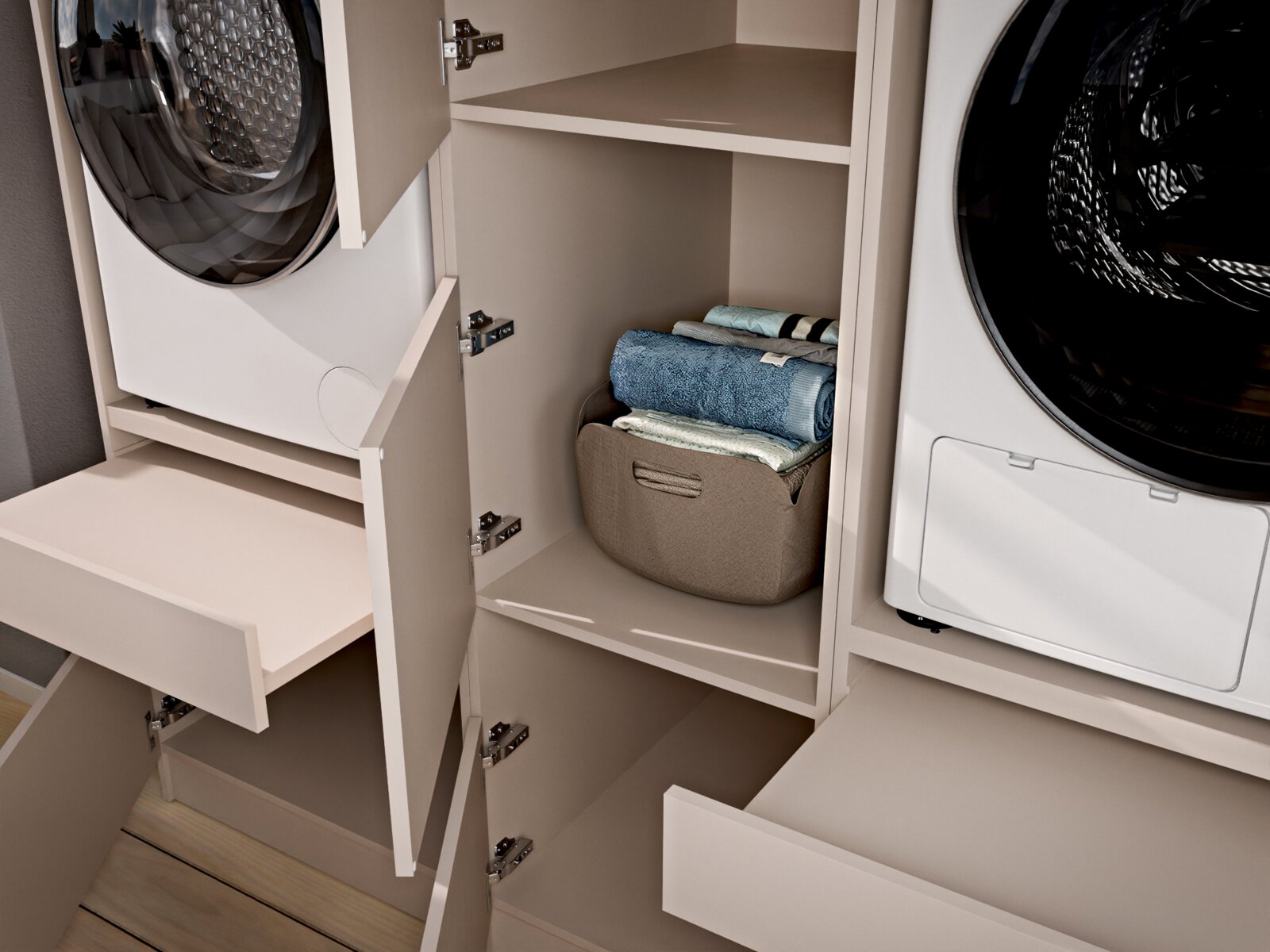 Offener Waschturm-/Hauswirtschaftsschrank in Beige mit integrierter Waschmaschine und Trockner sowie Ablagefächern und Wäschekorb, perspektivisch in schräger Nahaufnahme von vorn/seitlich aufgenommen