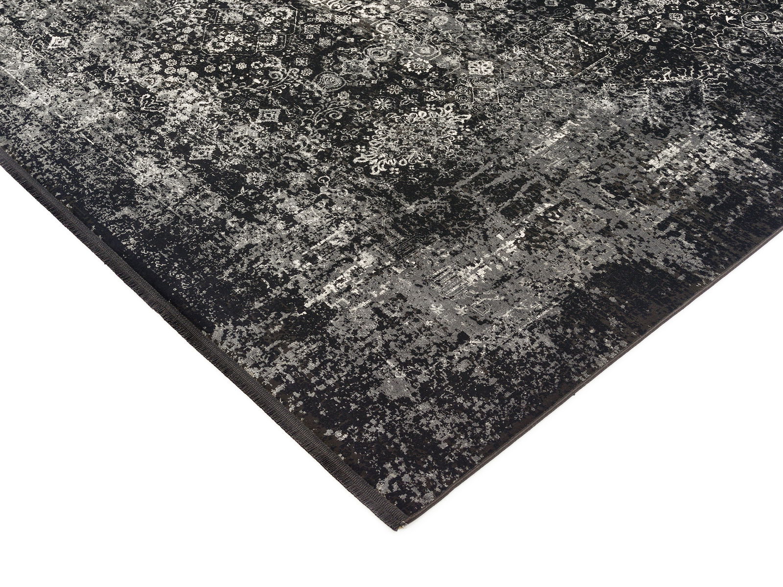 Designer Teppich in Schwarz und Grau mit komplexem Muster, perspektivisch von der Ecke aufgenommen