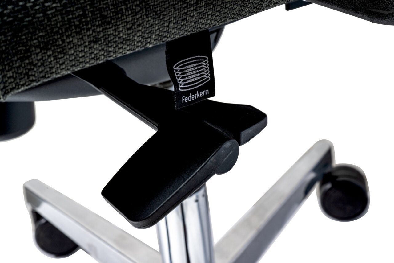 Nahaufnahme eines Drehstuhls mit Federkern, Fokus auf die Unterseite und die Rollen.