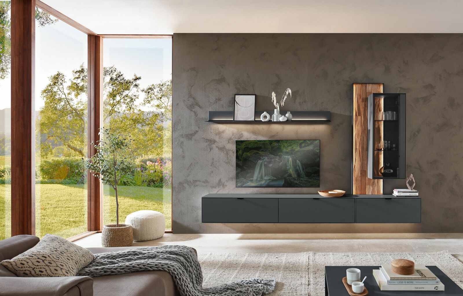 Dieter Knoll Wandboard RINA Modernes Wohnzimmer mit Wandboard in dunklem Design, dekoriert mit Vasen und Kunstobjekten, im Vordergrund eine gemütliche Sitzecke. Perspektive von der Seite.