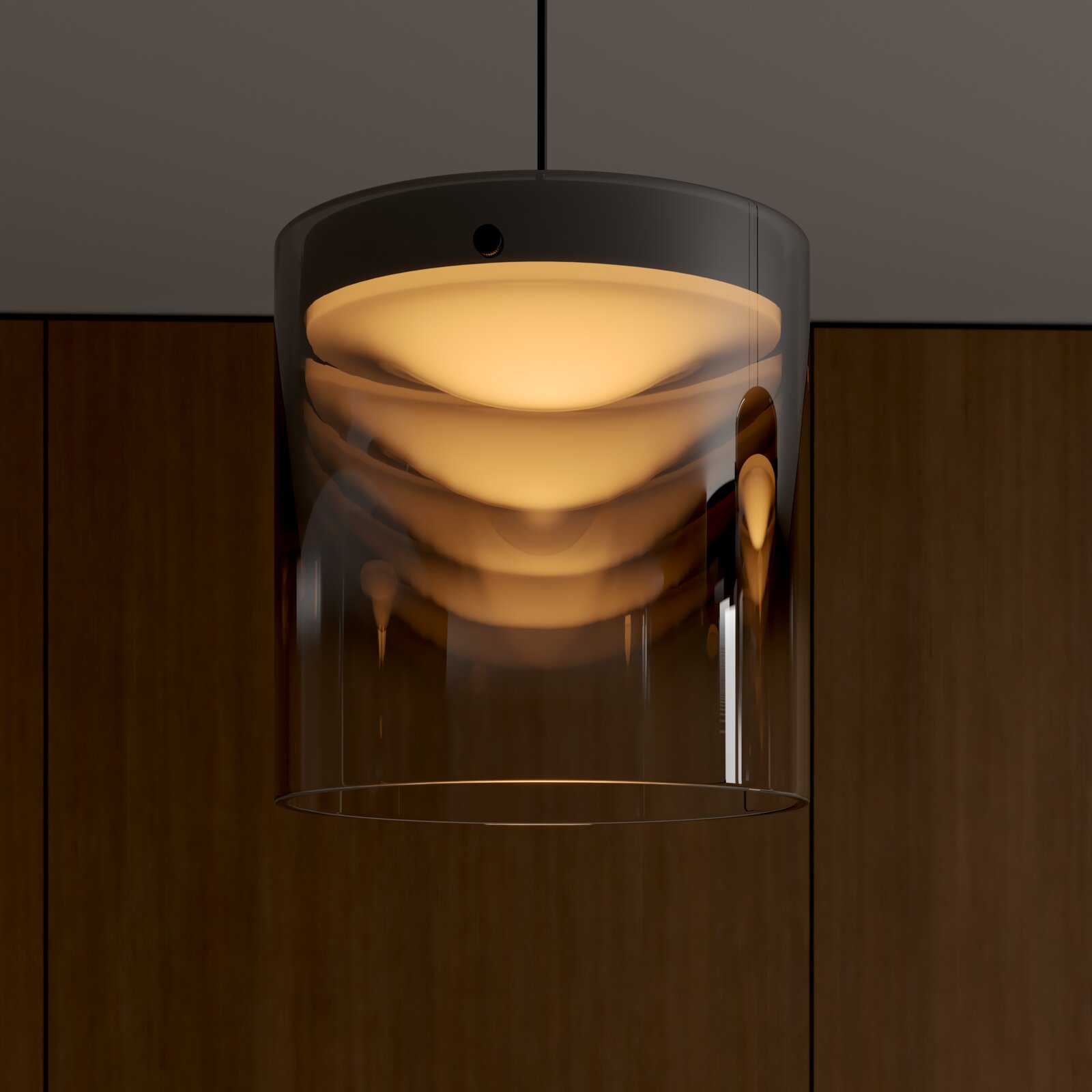Moderne Pendelleuchte mit transparentem, zylindrischem Glasschirm und warm leuchtendem Diffusor, frontale Nahaufnahme von leicht unten