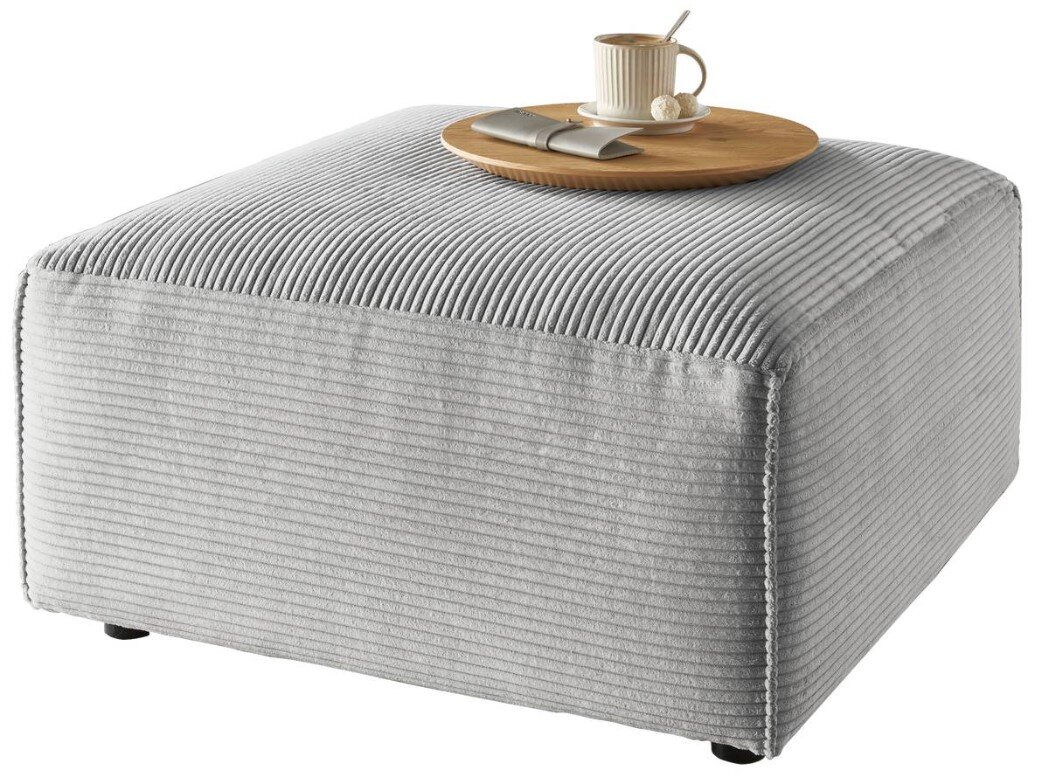 Grauer Hocker mit gerippter Oberfläche, darauf ein Tablett mit Tasse und Besteck, seitliche Perspektive