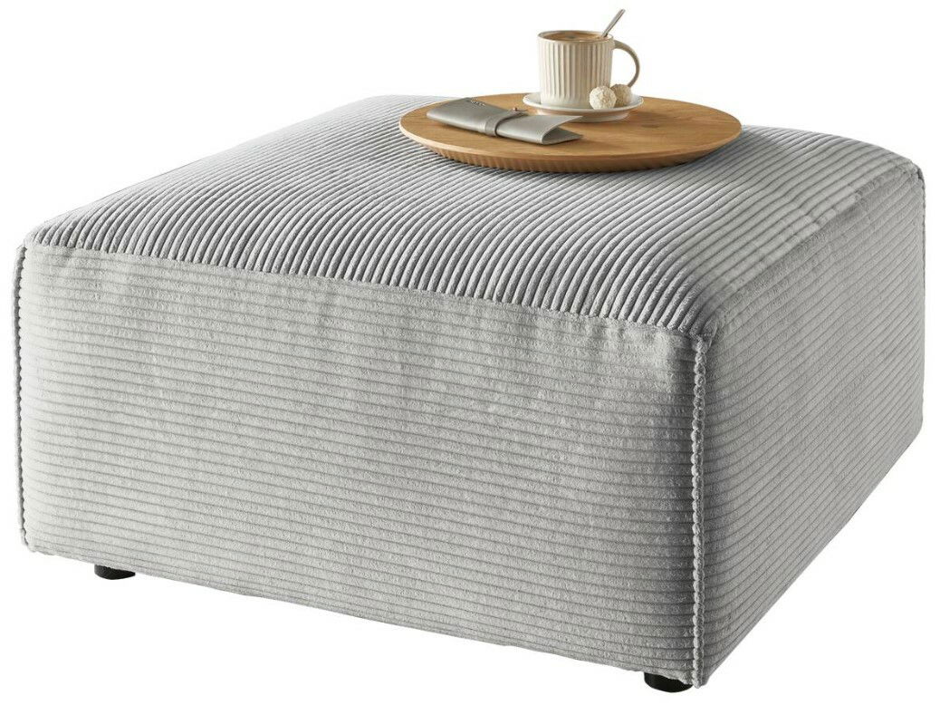 Grauer Hocker mit gerippter Oberfläche, darauf ein Tablett mit Tasse und Besteck, seitliche Perspektive