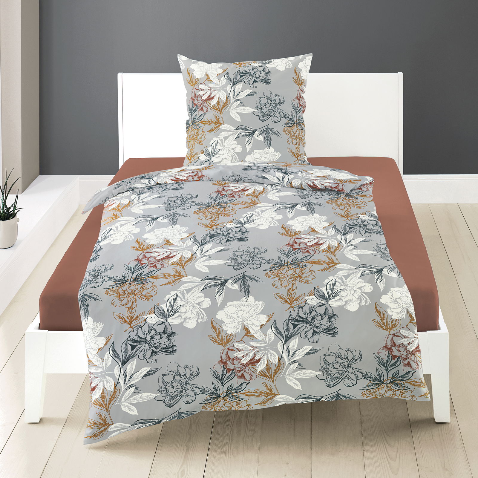 Bettwäsche-Set aus Mako-Satin mit floralem Muster in Grau, Weiß und Erdtönen, auf einem weißen Bettgestell in einem modernen Schlafzimmer, Vorderansicht