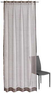 Vorhang in umbra Farbe mit Allover-Muster, frontal fotografiert, neben einem Stuhl