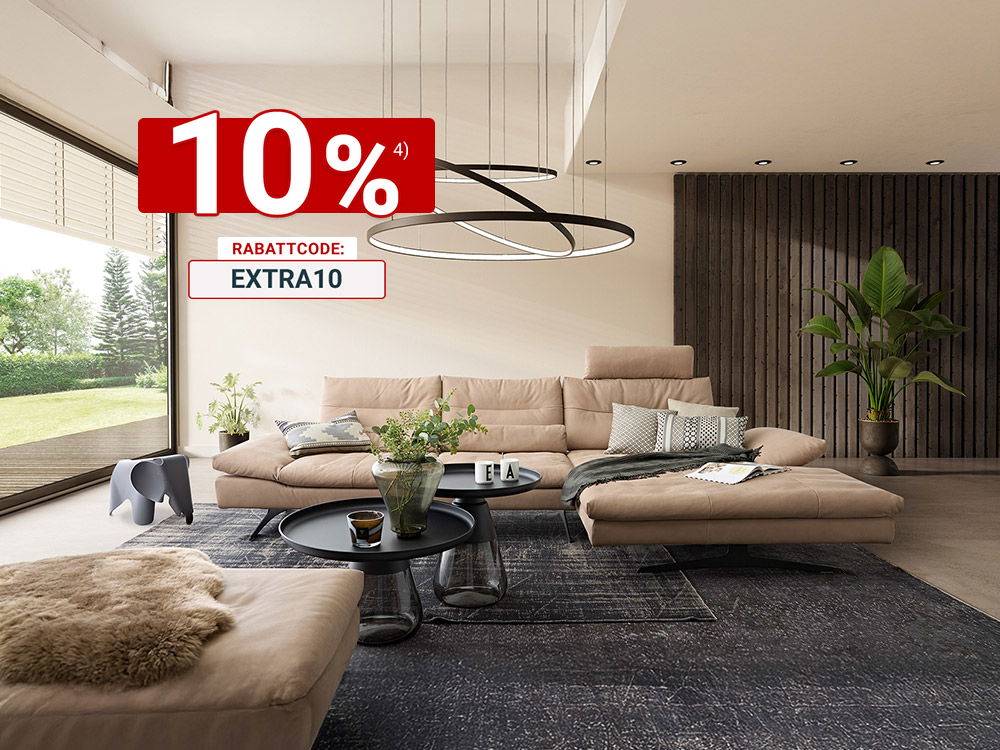 Modernes Wohnzimmer mit beigem Ecksofa, runden Couchtischen, Teppich und großer Pendelleuchte