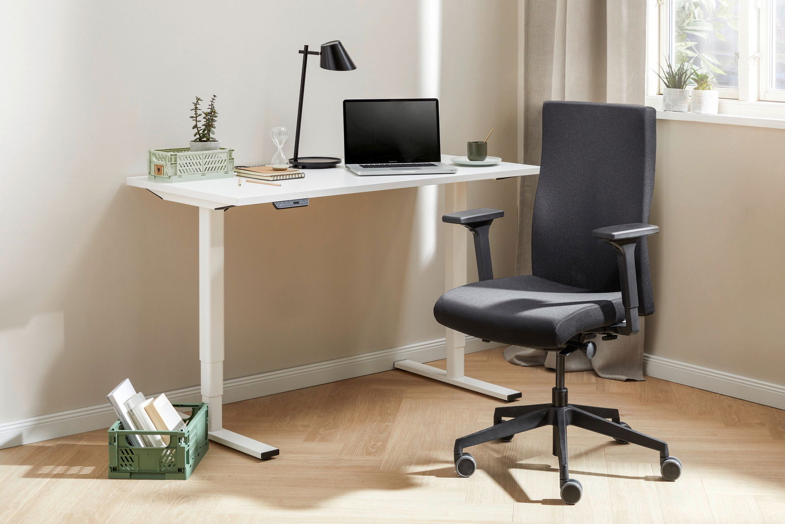 Moderner E-Schreibtisch Voleo Serie EFLEX in einem hellen Raum, seitliche Perspektive, mit Laptop, Lampe und Bürostuhl.