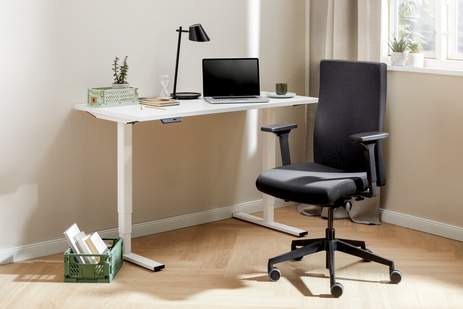 Moderner E-Schreibtisch Voleo Serie EFLEX in einem hellen Raum, seitliche Perspektive, mit Laptop, Lampe und Bürostuhl.