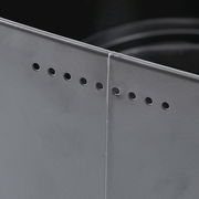 Nahaufnahme eines grauen Brotkastens mit Belüftungslöchern an der Ecke.