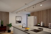 Moderne Küche mit URAIL Schienensystem und hängenden Lampen, seitliche Perspektive.