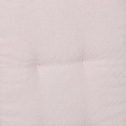 Nahaufnahme in Draufsicht auf hellbeigen, fein gewebten Stoff mit leichter Polsterung und zwei dezenten Knopfheftungen.
