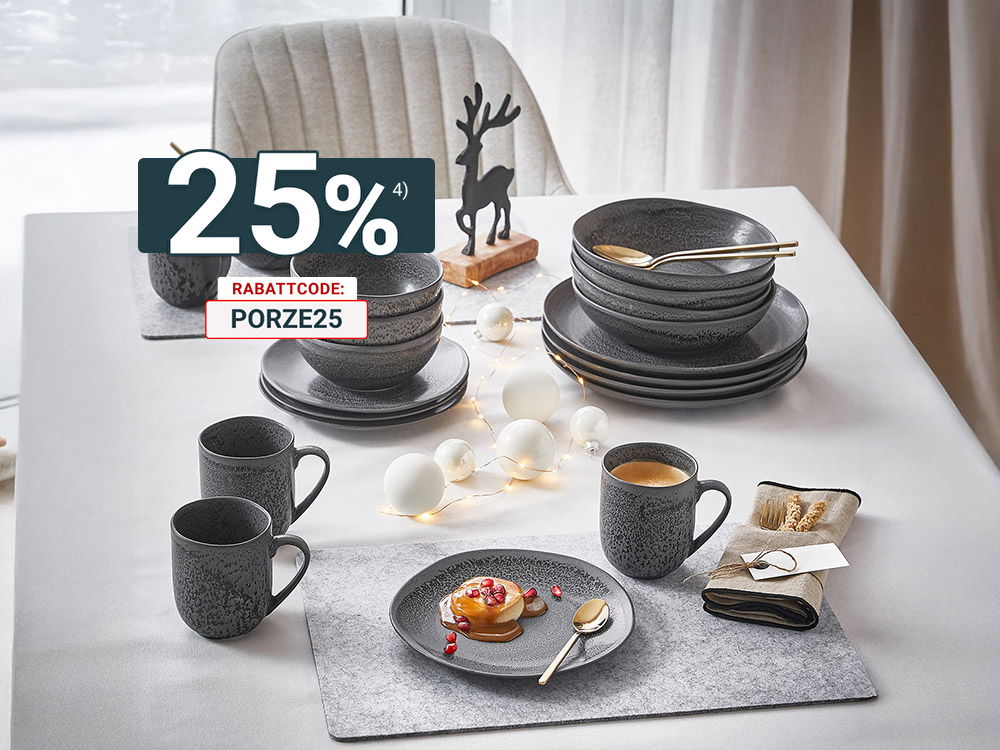 Festlich gedeckter Tisch mit dunkelgrauem Geschirr, Heißgetränken, Deko-Lichtern und kleinem Rentier als winterliche Tischdeko