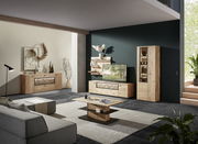 Moderne Wohnzimmerkombination aus Holz mit TV-Schrank, Vitrine und Wandregalen in einer stilvollen Raumansicht von schräg vorne.