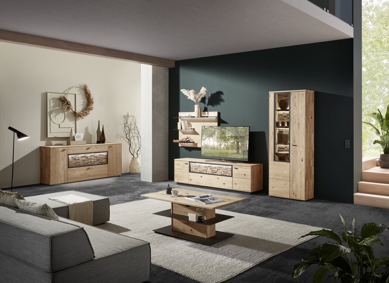 Valnatura Wandkombination VALS Moderne Wohnzimmerkombination aus Holz mit TV-Schrank, Vitrine und Wandregalen in einer stilvollen Raumansicht von schräg vorne.