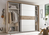 Moderner Schwebetürenschrank mit weißem und holzfarbenem Design, teilweise geöffnet, zeigt Kleidung und Accessoires im Inneren. Perspektive: Frontalansicht.