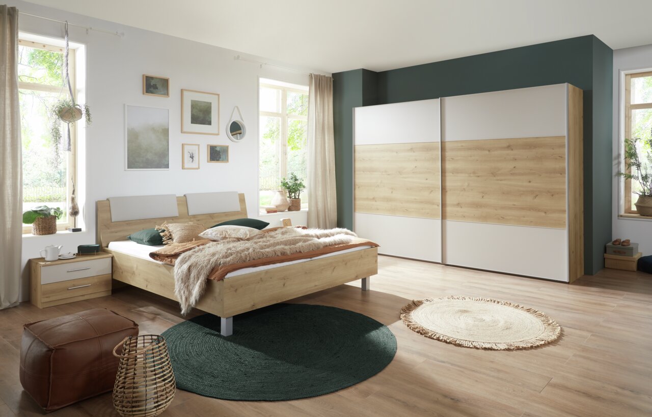 Moderne slaapkamer met houtlook, bestaande uit een tweepersoonsbed, een nachtkastje en een grote kledingkast. Het perspectief toont de kamer vanaf de zijkant, met uitzicht op het bed en de kast.