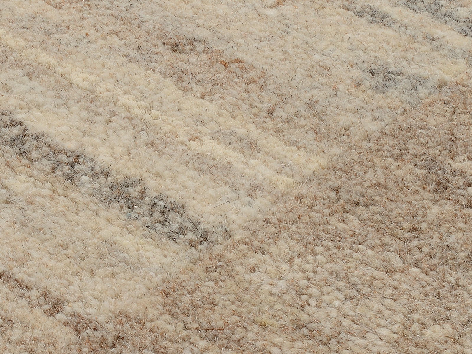 Nahaufnahme eines Wollteppichs mit natürlichen Beige- und Brauntönen, diagonale Perspektive
