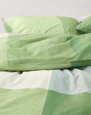 Grüne Bettwäsche mit geometrischem Muster, Nahaufnahme von oben