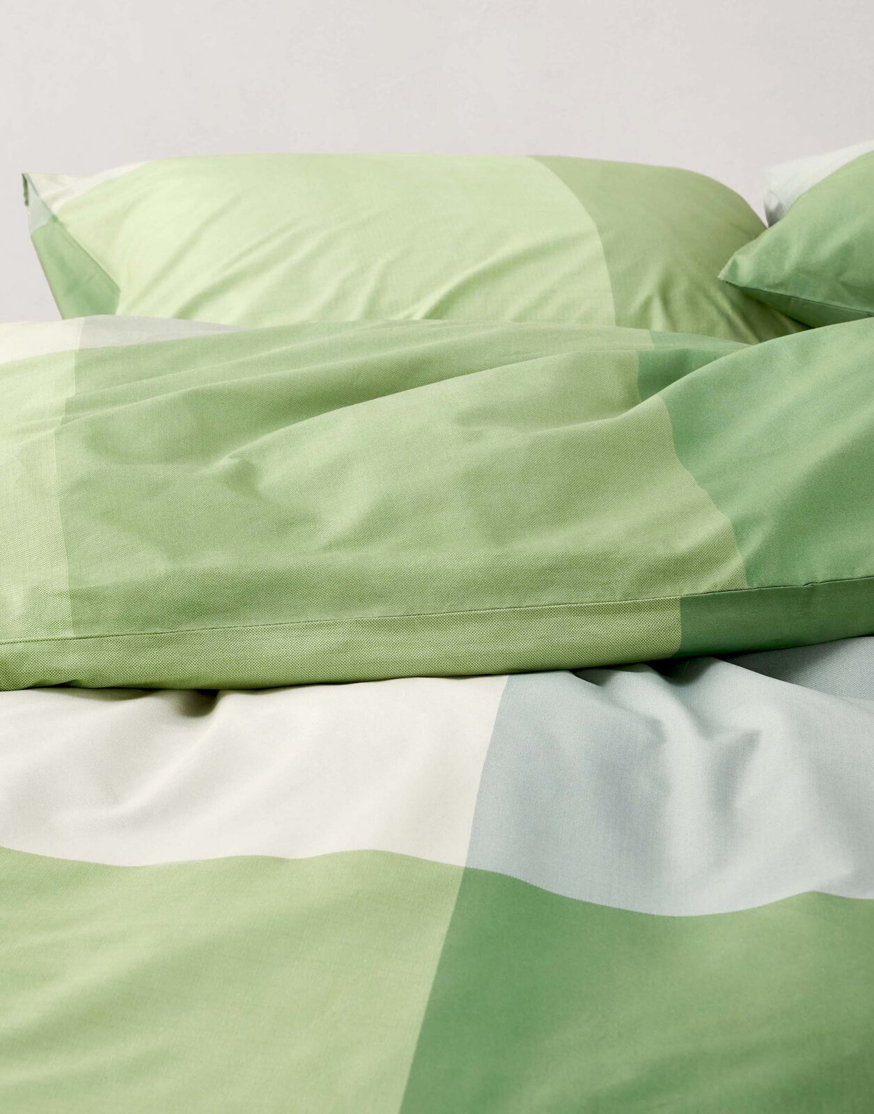 Groen beddengoed met geometrisch patroon, close-up van bovenaf