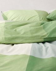 Groen beddengoed met geometrisch patroon, close-up van bovenaf