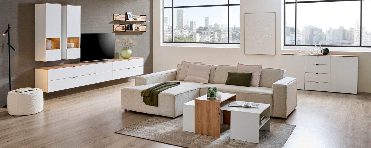 Moderne Wohnzimmeransicht mit Hängevitrine, die in einem stilvollen Raum mit Sofa, Couchtisch und TV platziert ist. Die Perspektive zeigt die Vitrine von vorne.