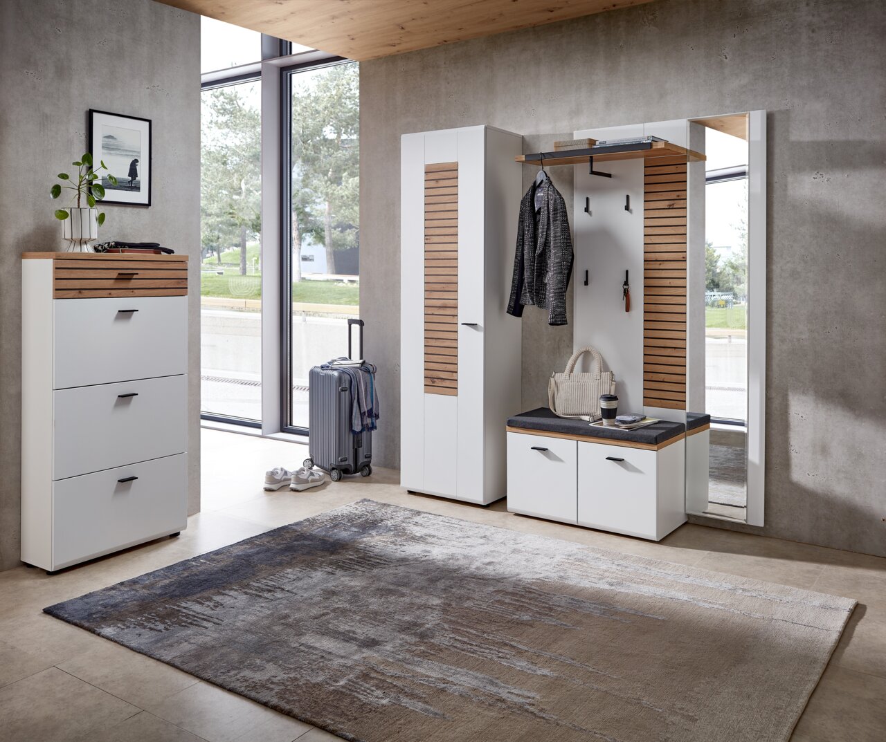 Moderne Garderobenkombination in einem hellen Raum mit großem Fenster, bestehend aus Schuhschrank, Garderobenschrank, Garderobenbank und Spiegel. Perspektive von vorne.
