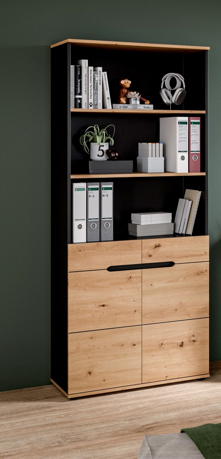 Modernes Regal-Schrankmöbel in Schwarz und Eicheoptik mit offenen Fächern und zwei Türen, dekoriert mit Büchern, Ordnern, Pflanze und Kopfhörern; frontale Ansicht mit leichter Perspektive von links.